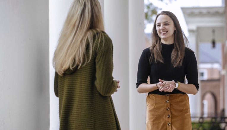 Two female students talking to each other outside