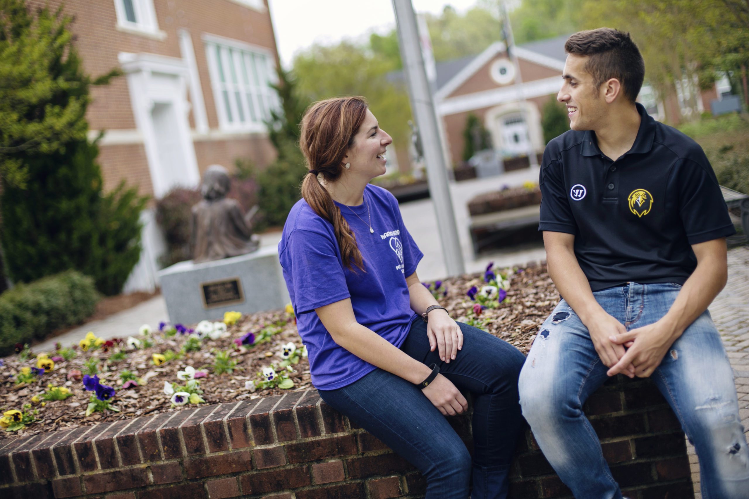 Two students outside smiling and having a conversation