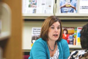 Instructor talking to students in library