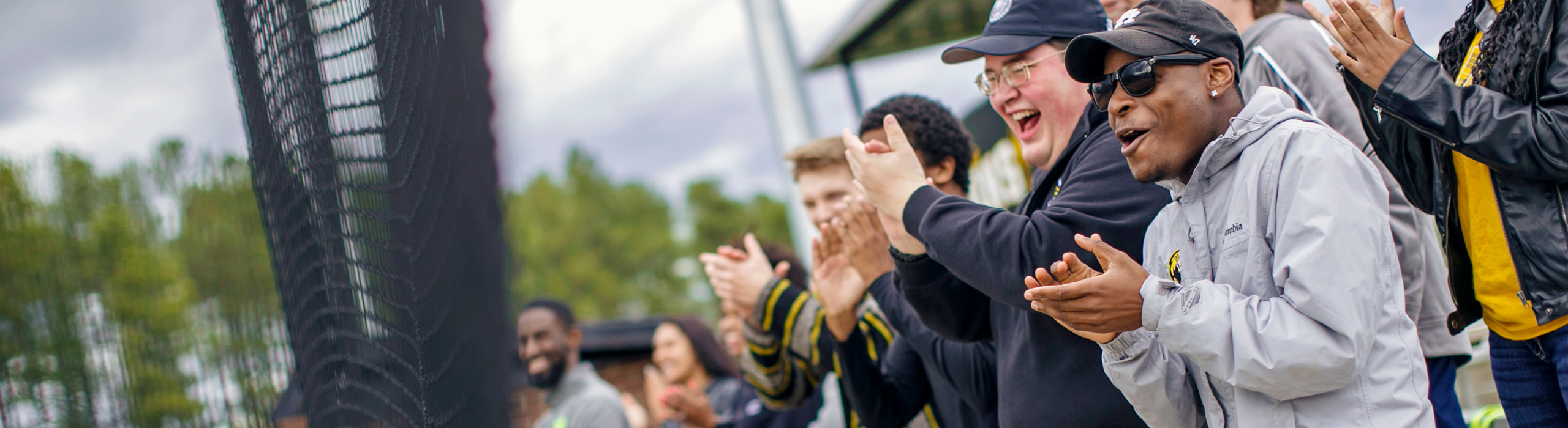 People clapping outside at athletic event